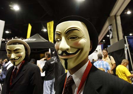 Two visitors wear masks from movie "V for Vendetta" as they walk during the 40th annual Comic Con Convention in San Diego July 23, 2009. The convention runs July 23-26. 