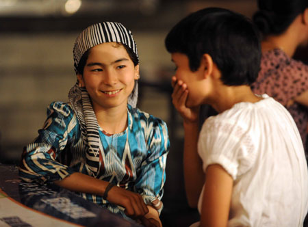 Two Uygur children chat at the most famous night fair in Urumqi, capital of northwest China's Xinjiang Uygur Autonomous Region, July 25, 2009. The Wuyi Starlight night fair, the biggest and most famous night fair in Urumqi, reopened here on July 21 for the first time since the deadly July 5 riot in the city.