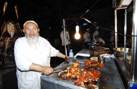 A Uygur man sells snacks at the most famous night fair in Urumqi, capital of northwest China's Xinjiang Uygur Autonomous Region, July 25, 2009. The Wuyi Starlight night fair, the biggest and most famous night fair in Urumqi, reopened here on July 21 for the first time since the deadly July 5 riot in the city. 