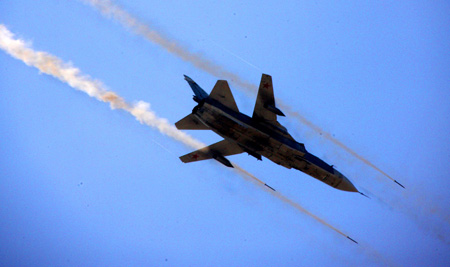 A Russian Su-24 fighter plane attends the real-combat of the 'Peace Mission-2009' joint anti-terror military exercise in Taonan of northeast China's Jilin Province, July 26, 2009. More than 100 tanks, self-propelled cannons, as well as more than 60 aircraft are fighting against 'terrorists' in the 80-minute final performance of the five-day exercises.[Li Gang/Xinhua]