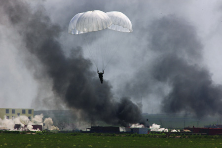 A Chinese soldier parachutes to the ground during the real-combat of the 'Peace Mission-2009' joint anti-terror military exercise in Taonan of northeast China's Jilin Province, July 26, 2009. More than 100 tanks, self-propelled cannons, as well as more than 60 aircraft are fighting against 'terrorists' in the 80-minute final performance of the five-day exercises. [Xinhua]