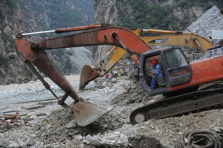 Rescuers clear the road destroyed by a massive landslide, triggered by heavy rain in Kangding county of the Garze Tibetan autonomous prefecture in southwest China's Sichuan province, July 25, 2009. At least four road construction workers were killed and at least 50 others injured in the incident.[Xinhua] 
