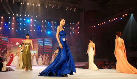 Models display evening dresses during the preliminary contest of the 10th CCTV Model Contest in Shishi of Quanzhou City in southeast China's Fujian Province, July 25, 2009. A total of 91 contestants competed during the contest in Shishi on Saturday, and some of them will attend the national final of the 10th CCTV Model Contest in Beijing in August. 