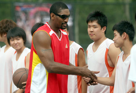 NBA basketball player Ron Artest of Los Angeles Lakers shakes hands with fans in Shenyang, capital of northeast China's Liaoning Province, July 26, 2009. (Xinhua/Zhang Wenkui)
