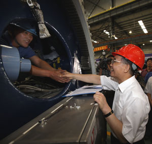 Chinese Premier Wen Jiabao (R) shakes hands with a worker while visiting Mingyang Datong Wind Power Technology Co., Ltd. in Jilin, a city of northeast China's Jilin Province, July 25, 2009. Wen made an inspection tour in Jilin Province from July 25 to 27. [Yao Dawei/Xinhua] 