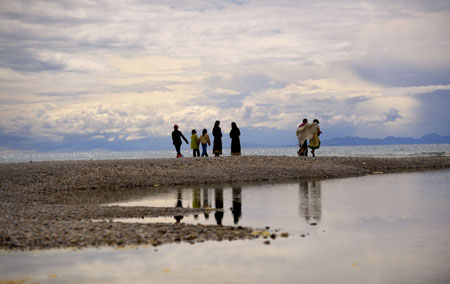 Tourists sightsee near Nam Co Lake, the highest saltwater lake of the world at 4,718 meters above the sea level, located at the boundary of Damxung and Baingoin counties, southwest China's Tibet Autonomous Region, July 26, 2009. Generally, tourists like visiting Nam Co Lake in summer, the most comfortable season in this region. [Purbu Zhaxi/Xinhua]