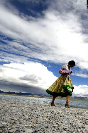 A tourist walks beside Nam Co Lake, the highest saltwater lake of the world at 4,718 meters above the sea level, located at the boundary of Damxung and Baingoin counties, southwest China's Tibet Autonomous Region. Generally, tourists like visiting Nam Co Lake in summer, the most comfortable season in this region. [Purbu Zhaxi/Xinhua]