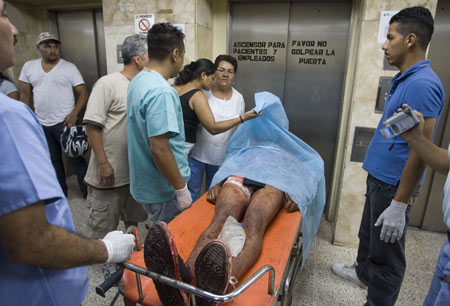 Relatives of a victim in the soccer fan clash identify the body at a hospital in Tegucigalpa, capital of Honduras, July 26, 2009.[David De La Paz/Xinhua]