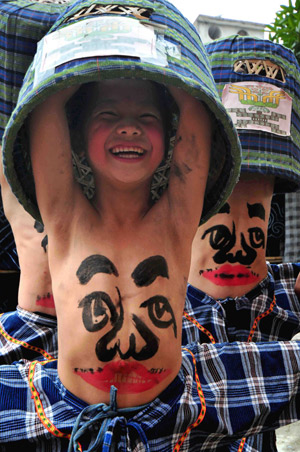 Children perform Wendangmu, a traditional local folk dance of some hundred years history, during a folk culture art festival held in Weng'ang Township in Libo County, southwest China's Guizhou Province, July 27, 2009. [Qin Gang/Xinhua]