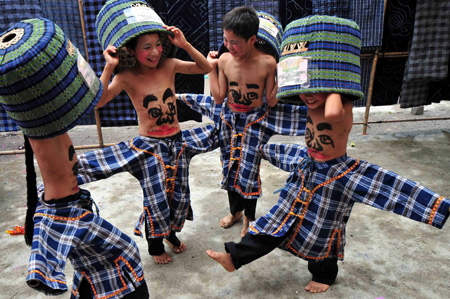 Children perform Wendangmu, a traditional local folk dance of some hundred years history, during a folk culture art festival held in Weng'ang Township in Libo County, southwest China's Guizhou Province, July 27, 2009. [Qin Gang/Xinhua]