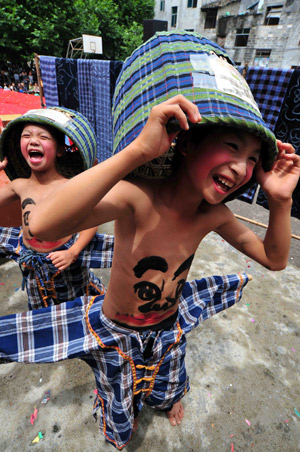 Children perform Wendangmu, a traditional local folk dance of some hundred years history, during a folk culture art festival held in Weng'ang Township in Libo County, southwest China's Guizhou Province, July 27, 2009. [Qin Gang/Xinhua]