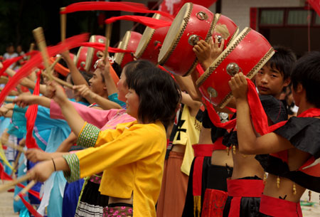Actors and actresses beat the drums at the opening of the Original Folk Culture Festival held in Qingzhen City of southwest China's Guizhou Province, July 26, 2009. Series of activities like folk culture tours, ethnic-styled competitions, folk custom photo shows, drug bathing, etc. will be held during the festival. (Xinhua/Jin Yulong)