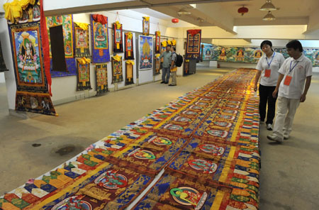 Visitors appreciate Tangka in the Yunnan Ethnical Museum in Kunming, southwest China's Yunnan Province, July 27, 2009. (Xinhua/Chen Haining)