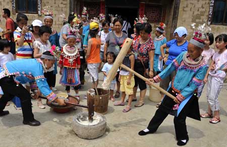 Women of the Miao ethnic group pound cooked glutinous rice into paste to demonstrate the producing method of Ciba, a traditional rice food, during the celebration activities in Geduo Village of Wangsi Township in Duyun City, southwest China's Guizhou Province, July 26, 2009. The local people celebrate the June 6 Festival according to the Chinese traditional lunar calendar. (Xinhua/Peng Nian) 