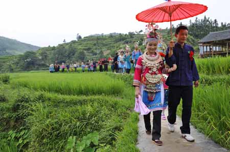 People of the Miao ethnic group take part in a wedding ceremony during the celebration activities in Geduo Village of Wangsi Township in Duyun City, southwest China's Guizhou Province, July 26, 2009. .(Xinhua/Peng Nian) 