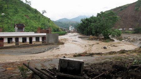 Flood runs through Miyi County, Panzhihua City, southwest China's Sichuan Province Monday July 27, 2009. [Xinhua]