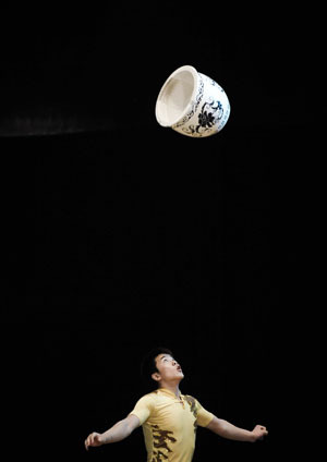 An actor from the Hebei Acrobatic Troupe of China performs Chinese acrobatics of 'Jar-Juggling' at Al Baloon Theater in Cairo, capital of Egypt, on July 27, 2009. [Xinhua]