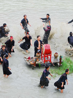 People of Miao ethnic group perform drum dance in a pond in Dagaowu Village of Gedong Township in Jianhe County, southwest China&apos;s Guizhou Province, July 26, 2009. The 2009 Guizhou Jianhe Yangasha Culture Festival was held here to commemorate Yangasha, a beautiful lady born in a well in the legend of Miao ethnic group. (Xinhua/Chen Peiliang)