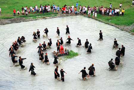 People of Miao ethnic group perform drum dance in a pond in Dagaowu Village of Gedong Township in Jianhe County, southwest China&apos;s Guizhou Province, July 26, 2009. The 2009 Guizhou Jianhe Yangasha Culture Festival was held here to commemorate Yangasha, a beautiful lady born in a well in the legend of Miao ethnic group. (Xinhua/Chen Peiliang)