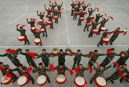 Policemen of Anhui armed police contingent play drums during a rehearsal for the celebration of the forthcoming 82nd anniversary of the founding of the Chinese People's Liberation Army in Hefei, capital of east China's Anhui Province, July 28, 2009. [Li Jian/Xinhua]