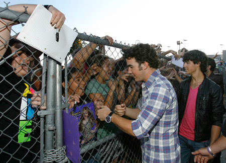 The Jonas brothers (L-R) Kevin, Joe and Nick, greet fans at a special screening of the animated movie 'Ponyo' at El Capitan theatre in Hollywood, California July 27, 2009. [Xinhua/Reuters]