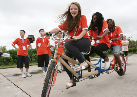 Three students from Britain ride trio-bicycle as they attend the Sino-British Sports and Culture Summer Camp held in Haimen City of east China's Jiangsu Province, July 28, 2009. The week-long summer camp provided chances for Chinese and British students to communicate on sports and culture.[Xinhua]