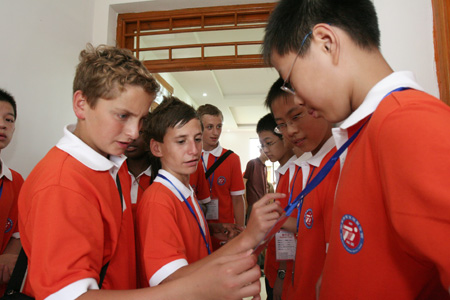 Chinese and British students talk after class as they attend the Sino-British Sports and Culture Summer Camp held in Haimen City of east China's Jiangsu Province, July 28, 2009. [Xinhua]