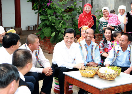 Chinese President Hu Jintao (C) smiles during a chat with residents of Hui nationality and Yi nationality at Mashipu village in Chuxiong, southwest China's Yunnan Province, July 26, 2009. Hu inspected the province from July 25 to July 28.[Xinhua]