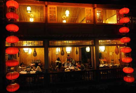 Tourists dine at a restaurant in Lijiang, a tourist resort in southwest China's Yunnan Province, July 27, 2009.(Xinhua/Lin Yiguang)