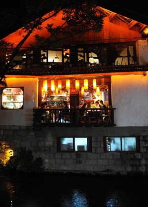 Tourists enjoy their leisure time at a pub in Lijiang, a tourist resort in southwest China's Yunnan Province, July 27, 2009.(Xinhua/Lin Yiguang)