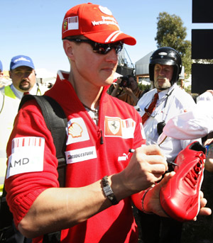Former Formula One world champion and Ferrari driver Michael Schumacher of Germany signs autographs as he arrives at Albert Park race track for the Australian F1 Grand Prix in Melbourne March 29, 2009. (Xinhua/Reuters File Photo)