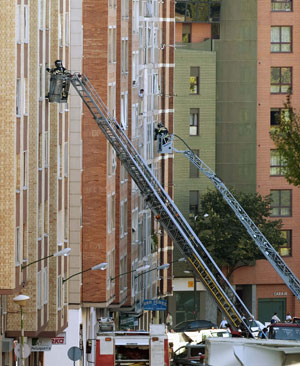 Firemen inspect damage to buildings in front of a Civil Guard barracks after a car bomb exploded in the northern Spanish city of Burgos, early July 29, 2009.[Xinhua/Reuters]