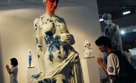 People visit at the fourth Chengdu Biennial Exhibition in Chengdu, capital of southwest China's Sichuan Province, July 29, 2009. [Jiang Hongjing/Xinhua] 