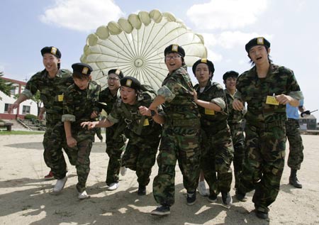 Student trainees pull a parachute during a summer military camp for civilians organised by South Korean Special Warfare Command at a military training field in Seoul July 29, 2009. About 700 civilians including middle and high school students have been participating in a four-day-camp at three military units across the country to strengthen themselves mentally and physically and to promote national security awareness.[Xinhua/Reuters]