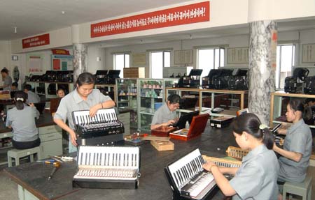 The photo released by KCNA news agency on July 29, 2009 shows workers assemble accordions in the Pyongyang Musical Instrument Factory in Pyongyang, the Democratic People's Republic of Korea. [Xinhua/KCNA] 