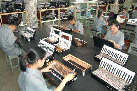 The photo released by KCNA news agency on July 29, 2009 shows workers assemble accordions in the Pyongyang Musical Instrument Factory in Pyongyang, the Democratic People's Republic of Korea. [Xinhua/KCNA] 