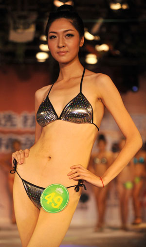 Winner Kou Yujie displays swimming suit during the New Face model competition in Taiyuan, capital of north China's Shanxi Province, July 28, 2009. The New Face model competition concluded on Tuesday with contestants Guo Jie and Kou Yujie winning the competition. [Meng Chenguang/Xinhua] 