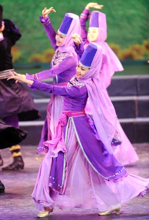 Artists of song and dance ensemble of Xinjiang Art Theater dance during a performance for police officers in Urumqi, capital of northwest China's Xinjiang Uygur Autonomous Region, July 29, 2009, one of the activities to greet the coming August 1, the Chinese Army's birthday. [Sadat/Xinhua] 