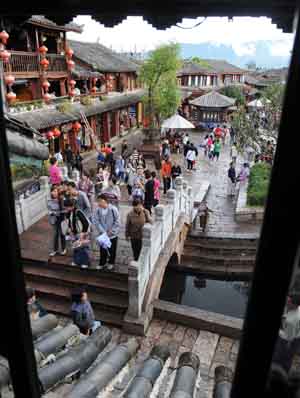 Tourists walk on a street in Lijiang, southwest China's Yunnan Province, on July 27, 2009.[Lin Yiguang/Xinhua]