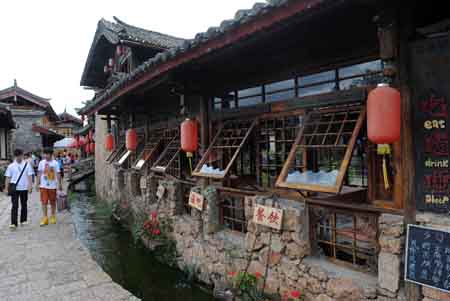 Tourists visit the ancient Shuhe Town of Lijiang city, southwest China's Yunnan Province, on July 29, 2009.[Lin Yiguang/Xinhua]