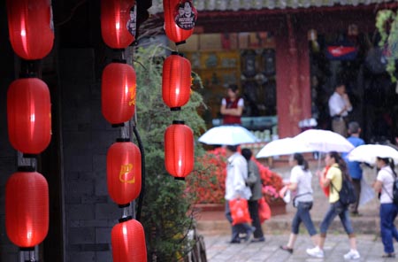 Tourists walk on a street in Lijiang, southwest China's Yunnan Province, on July 29, 2009. [Lin Yiguang/Xinhua]