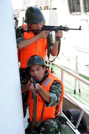 The armed policemen take part in an anti-terrorism drill in Lianyungang City, east China's Jiangsu Province, July 29, 2009. An anti-terrorism drill to test and improve the ability of marine police to handle emergencies was held here on Wednesday to greet the 82nd anniversary of the founding of the Chinese People's Liberation Army, which falls on Aug. 1. [Wang Chun/Xinhua]