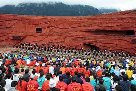 Tourists watch a performance in Lijiang, southwest China's Yunnan Province, on July 28, 2009.(Xinhua/Lin Yiguang) 