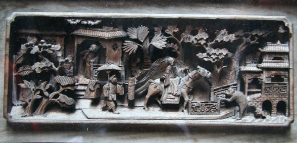 This wood carving on the wall of Zhicheng Hall tells a story about an intellectual (riding the horse) in ancient China who expected to ace the imperial examinations so he could start an official career. A young male attendant carries his bags. [Photo: CRIENGLISH.com]
