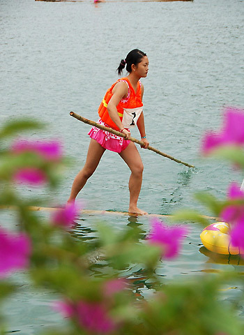 A participant paddles forward during a bamboo drift racing in Majiang county, southwest China's Guizhou province, July 29, 2009. [Xinhua]