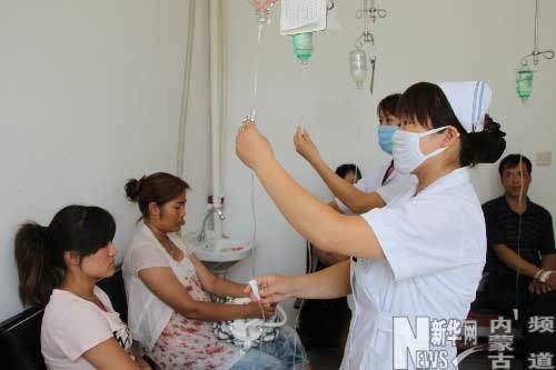 A medical worker gives treatment to local people on July 28, 2009. Altogether 2,622 people have sought medication for gastrointestinal illness after the tap water supply was contaminated by rainfall on July 25 in Chifeng City of north China's Inner Mongolia Autonomous Region.