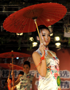 A contestant shows Qipao, a Chinese traditional costume, during the New Face model competition in Taiyuan, capital of north China's Shanxi Province, July 28, 2009. The New Face model competition concluded on Tuesday with contestants Guo Jie and Kou Yujie winning the competition.