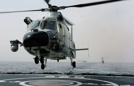 Carrier-based helicopter takes off from Zhoushan missile frigate before joining the Second Chinese naval escort on the Gulf of Aden, July 30, 2009. Two frigates and a supply ship from the Chinese navy, on another escort mission to fend off Somali pirates, joined with the second naval escort on Thursday.[Guo Gang/Xinhua]