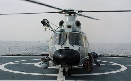 Carrier-based helicopter takes off from Zhoushan missile frigate before joining the Second Chinese naval escort on the Gulf of Aden, July 30, 2009. Two frigates and a supply ship from the Chinese navy, on another escort mission to fend off Somali pirates, joined with the second naval escort on Thursday.[Guo Gang/Xinhua]