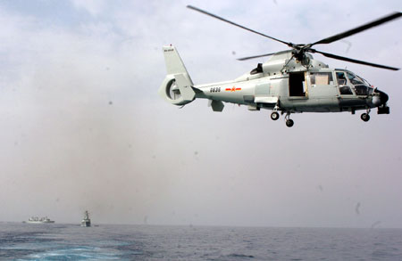 Carrier-based helicopter takes off from Zhoushan missile frigate before joining the Second Chinese naval escort on the Gulf of Aden, July 30, 2009. Two frigates and a supply ship from the Chinese navy, on another escort mission to fend off Somali pirates, joined with the second naval escort on Thursday.[Guo Gang/Xinhua]